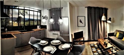 een keuken en een woonkamer met een tafel en stoelen bij Appartement sous les remparts in Carcassonne