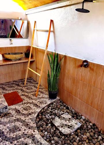 a bathroom with a shower with a stone floor at Raturinjani homestay in Selong