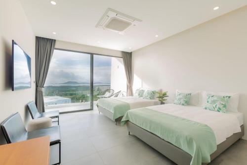 Habitación de hotel con 2 camas y ventana en Yamu Hills Panoramic Ocean View 6 Bed Luxury Pool Villa - Phuket, en Phuket