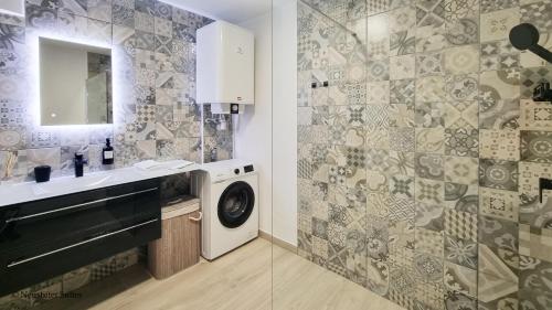 een badkamer met een wastafel en een wasmachine bij St. Antoni Suite 3 in Eisenstadt