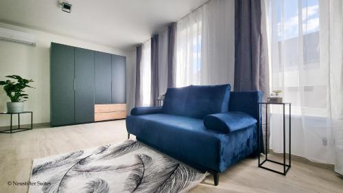 a blue chair in a room with a large window at St. Antoni Suite 3 in Eisenstadt