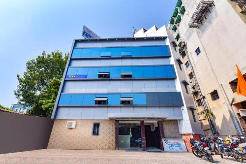 un alto edificio blu con moto parcheggiate di fronte di FabHotel Shri Krishna a Vadodara