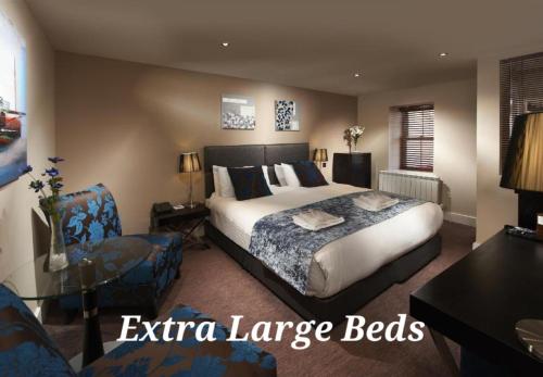a bedroom with a bed and a table and a chair at Duke Of Normandie in St Peter Port