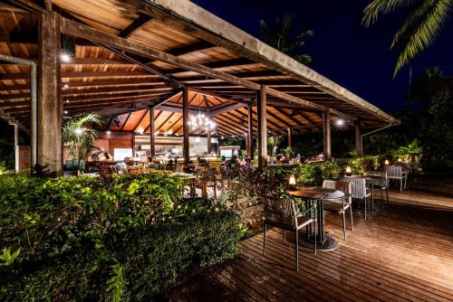 a restaurant with tables and chairs on a deck at night at Barcelo Coconut Island, Phuket in Phuket Town