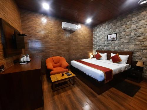 um quarto com uma cama e uma cadeira laranja em JHARNA RESORT em Purulia