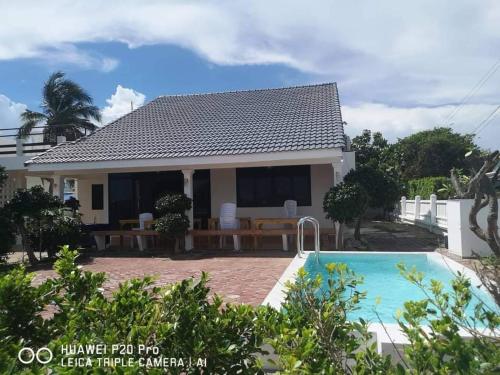 a villa with a swimming pool and a house at Sealife6 Beach Pool villa in Ban Nong Si Tong