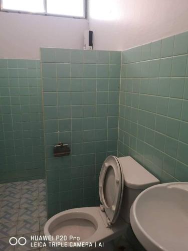 a green tiled bathroom with a toilet and a sink at Sealife6 Beach Pool villa in Ban Nong Si Tong