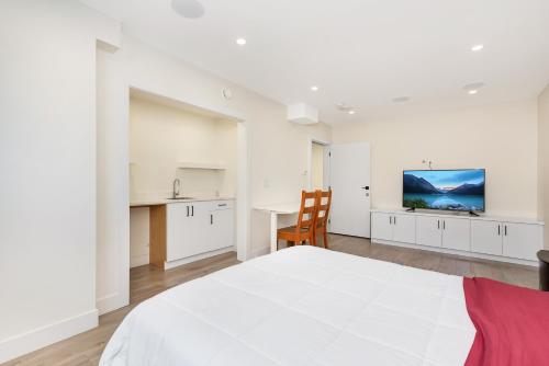 a white bedroom with a large bed and a table at William Place in Surrey
