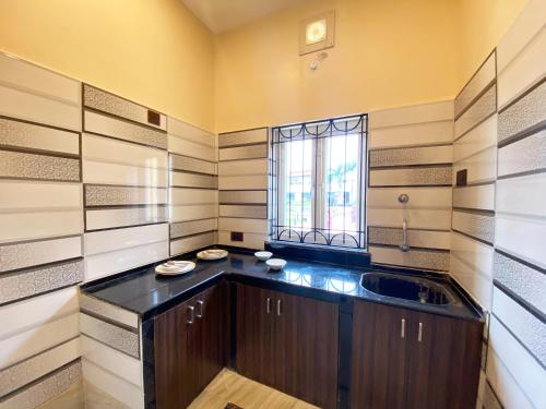 uma grande cozinha com um lavatório e uma janela em JHARNA RESORT em Purulia