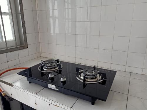a black stove top with two pans on top at BS Home in Miri City - 3R2B House Pelita Commercial Centre in Miri