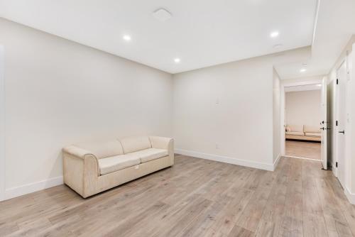 an empty living room with a couch and wooden floors at William Place in Surrey