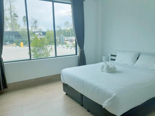 um quarto com uma cama grande e uma janela grande em Bouasavan Hotel and Garden em Savannakhet