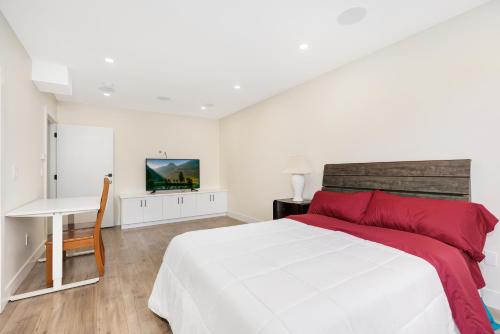 a white bedroom with a large bed and a desk at William Place in Surrey