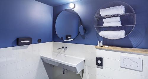 a bathroom with a sink and a mirror and towels at Best Western Plus Hotel Cargo in Dunkerque