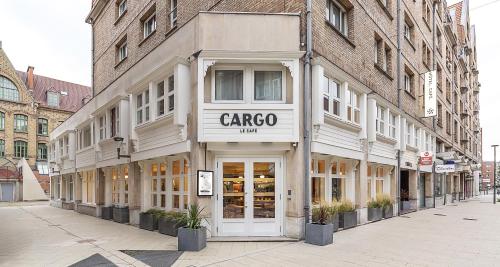 a building on a street with a carco store at Best Western Plus Hotel Cargo in Dunkerque