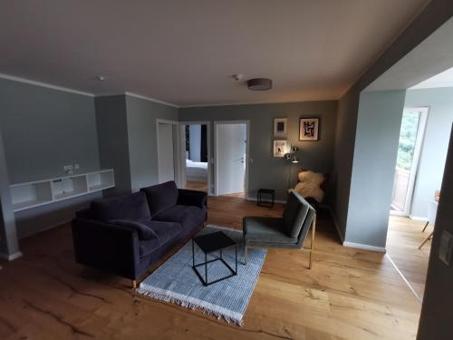 a living room with a couch and a chair at Panorama Spa Lodges DAS.SCHILLER in Bad Gastein