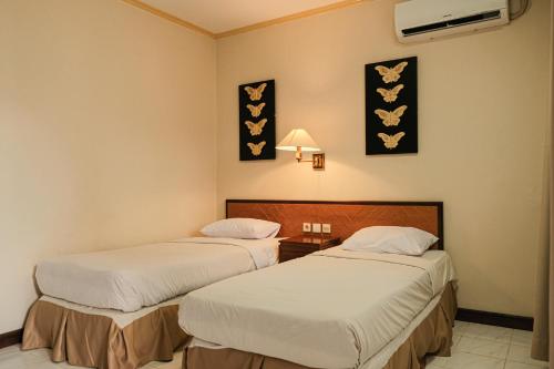 a hotel room with two beds in a room at Royal Brongto Hotel in Timuran
