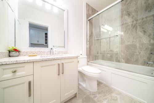 a white bathroom with a toilet and a shower at William Place in Surrey