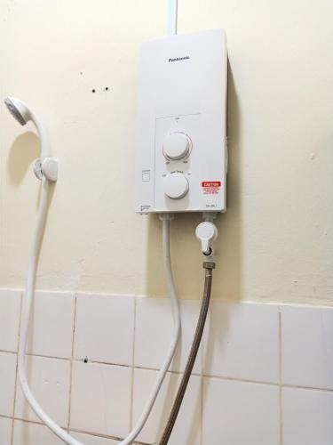 a water hose hooked up to a wall with a white outlet at BS Home in Miri City - 3R2B House Pelita Commercial Centre in Miri