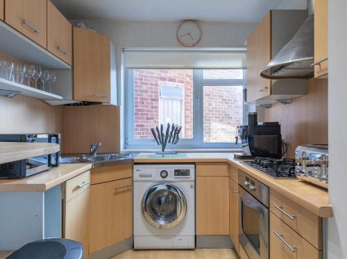 a kitchen with a washing machine and a window at Park View - Modern - Parking in Brighton & Hove