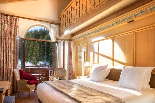 a bedroom with a large bed and a large window at Hotel Carlina in Courchevel