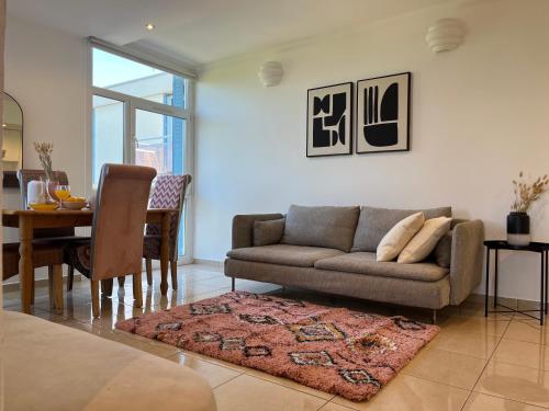 un salon avec un canapé et une table dans l'établissement Suite Miramar - Check in h24 - Wifi, à Bron