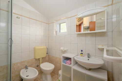 a bathroom with a toilet and a sink and a mirror at Villa Ana - Peaceful Location in Marčana
