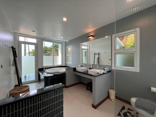 a bathroom with a sink and a tub and a mirror at Krabi Beach House, SHA Extra Plus in Ao Nam Mao