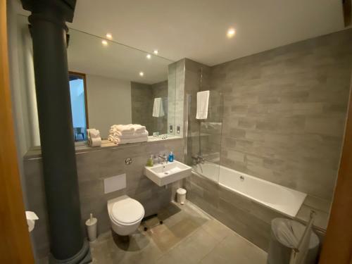 a bathroom with a toilet and a sink and a bath tub at Buckingham Place at the Royal William Yard in Plymouth