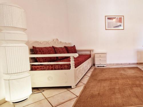 a bedroom with a white bed with red pillows at Panorama Apartments Fiscardo in Fiskardo