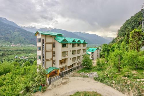an aerial view of a building with mountains in the background at Katson Blue Manali in Manāli