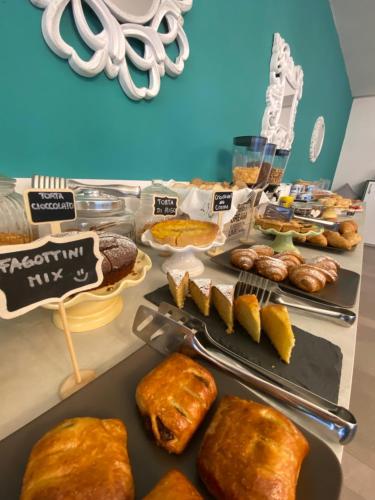 a buffet with different types of bread and pastries at Hotel Smart Cervia B&B in Cervia