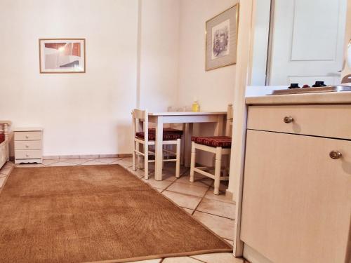 a kitchen with a table and a kitchen rug at Panorama Apartments Fiscardo in Fiskardho