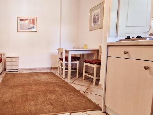 a kitchen with a table and a kitchen rug at Panorama Apartments Fiscardo in Fiskardo