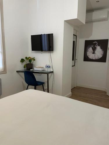 Chambre moderne, proche Monaco في بوسولاي: غرفة نوم مع سرير ومكتب وتلفزيون على الحائط