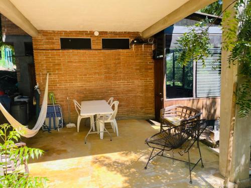 a patio with a table and chairs and a brick wall at Double Bed, Queen size, small kitchen, terrace, wi-fi- air condition in Cuatunalco