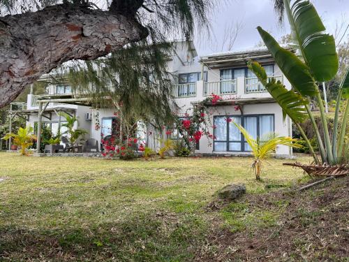 a white house with a palm tree in front of it at COCO MANGO Villa in Trèfles