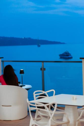 a person sitting at a table with a blue light at Hotel Giosue' a mare Sorrento in Meta