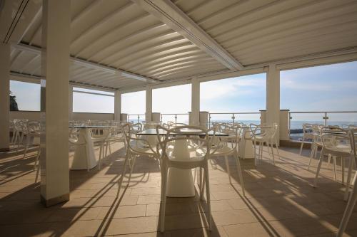 a room with tables and chairs on a balcony at Hotel Giosue' a mare Sorrento in Meta