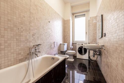 uma casa de banho com uma banheira, um WC e um lavatório. em Ca' Magenta em Milão