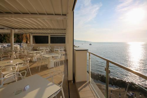 a balcony with tables and chairs and the ocean at Hotel Giosue' a mare Sorrento in Meta