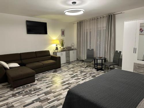 a bedroom with a couch and a living room at Apartmány Piller in Roudnice nad Labem