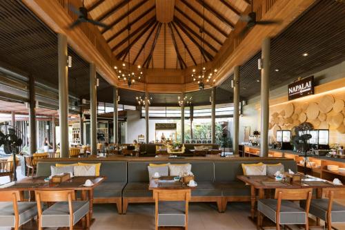 a restaurant with wooden tables and chairs and a bar at Apsara Beachfront Resort & Villa in Khao Lak