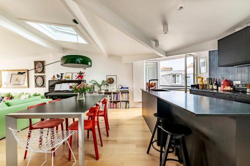 une cuisine et un salon avec une table et des chaises dans l'établissement Veeve - Montparnasse Medley, à Paris