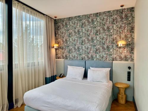 ein Schlafzimmer mit einem Bett und einer Blumenwand in der Unterkunft Abanotubani Boutique hotel in Tbilisi City