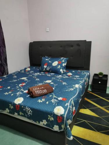 1 cama con edredón azul y almohada en Tok Wan Roomstay en Kampong Banggol Binjai