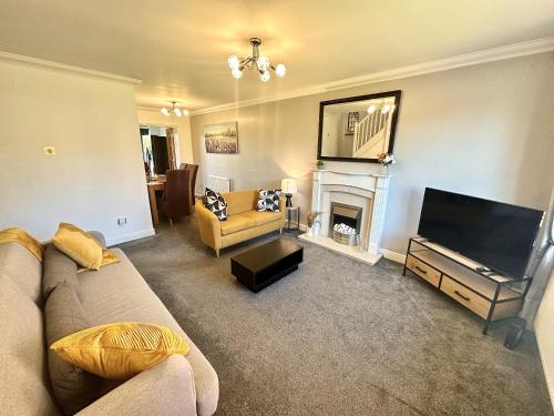 sala de estar con sofá y chimenea en 3 Bed Home for Contractors & Relocators with Parking, Garden & WiFi 30 mins to Alton Towers en Stoke on Trent