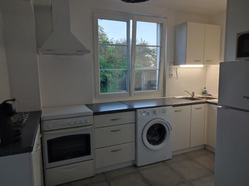 une cuisine avec un lave-linge et un réfrigérateur dans l'établissement La petite maison, à Mesnil-Saint-Nicaise