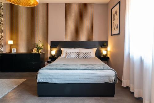 une chambre avec un grand lit et deux tables de nuit dans l'établissement Villaggio Tranquillo - bambnb, à Vinovo