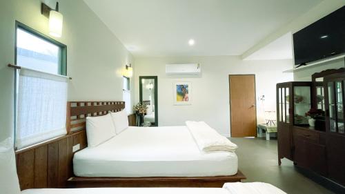 a bedroom with two beds and a window at Rimsira in Chumphon